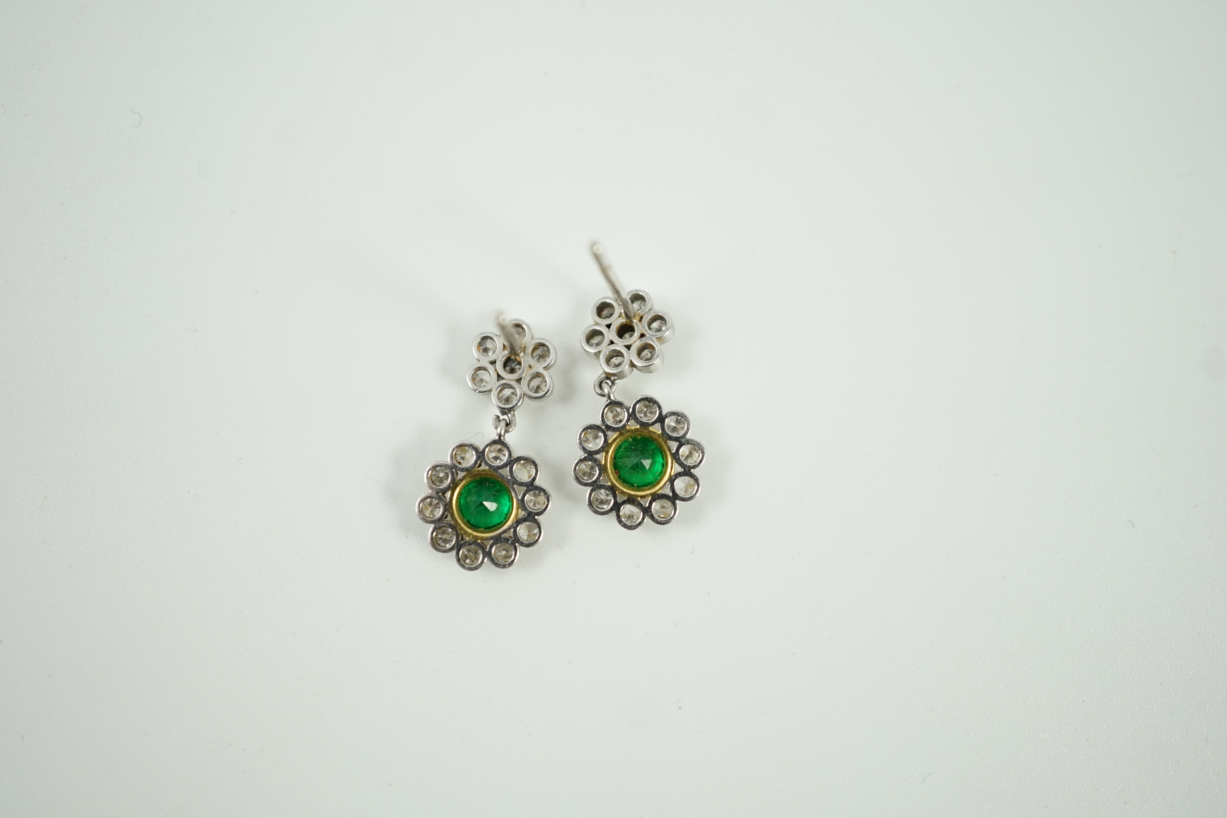 A modern pair of 18ct white gold, emerald and diamond cluster set drop earrings, 16mm, gross weight 3 grams.